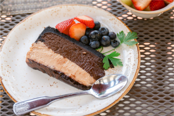 A stoneware plate of chocolate cake with fruit